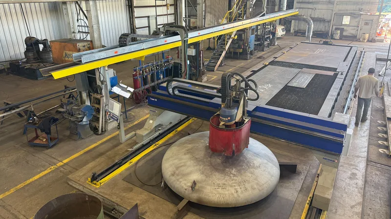 CNC burn table in the Ramco shop with a dished tank head on the bed